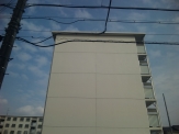 壁が白い建物があり、その奥に似た建物がある。